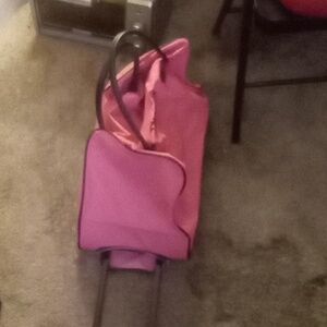 Pink travel bag with the name pamela on it and backpack